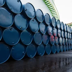 worker-inspects-blue-oil-drums-shutterstock (1)