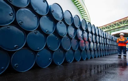 worker-inspects-blue-oil-drums-shutterstock (1)